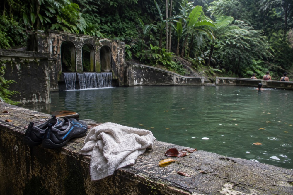Sturdy water shoes drying on a rock beside a forest stream