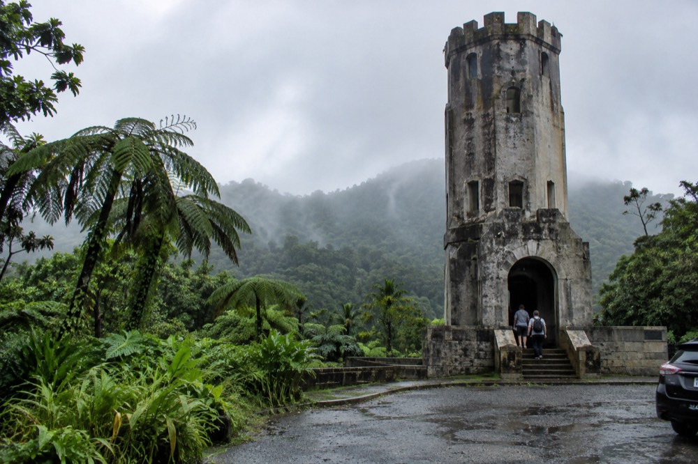 A stone observation tower rising above the rainforest canopy on a hazy morning