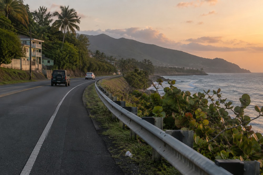 A coastal highway curving toward green mountains in the early morning