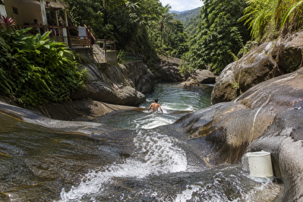 A narrow rocky stream channel with smooth rock walls and flowing water