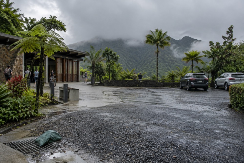 A cloud-covered forest ridge seen from a cleared pull-off along a mountain road