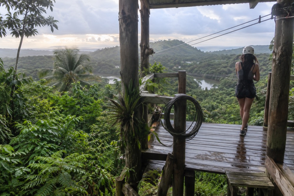 A zipline platform built on a wooden tower above thick rainforest foliage