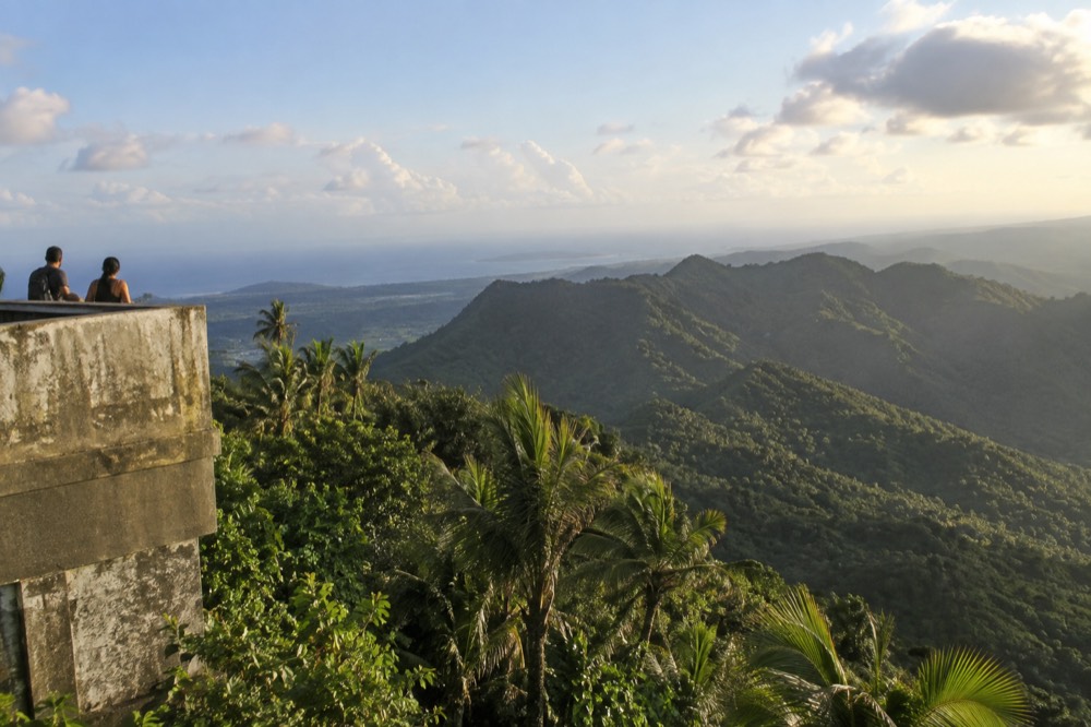 Tropical forest landscape with layered ridges under a bright sky